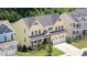 Aerial view of a traditional two-story yellow house with a well-manicured lawn and two-car garage at 1131 Lowland St, Apex, NC 27523
