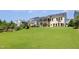 Wide green lawn leading up to a yellow two-story house with a screened porch at 1131 Lowland St, Apex, NC 27523