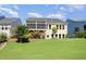 Landscaped backyard featuring a terraced lawn and a yellow two-story house with a screened porch at 1131 Lowland St, Apex, NC 27523