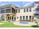 Back exterior view of a bright yellow two-story home with a screened porch and plunge pool at 1131 Lowland St, Apex, NC 27523