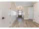 Bright foyer with wood-look floors, white wainscoting, and a decorative light fixture at 1131 Lowland St, Apex, NC 27523