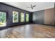 Living area with dark walls, wood floors, windows with natural light, and door to outside at 1131 Lowland St, Apex, NC 27523