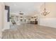 Open living room with wood-look floors, fireplace, large windows, and seamless access to the kitchen at 1131 Lowland St, Apex, NC 27523