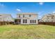 Wide backyard view featuring lush lawn, fenced perimeter, and the home's back with a screened-in porch at 116 Hayfield Dr, Lillington, NC 27546