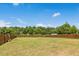Expansive backyard with lush green grass, privacy fence and mature trees in the distance at 116 Hayfield Dr, Lillington, NC 27546