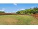 Spacious backyard featuring a well-maintained lawn, surrounded by a tall wooden fence and mature trees at 116 Hayfield Dr, Lillington, NC 27546