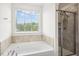 Bright bathroom featuring a soaking tub and tiled shower at 116 Hayfield Dr, Lillington, NC 27546