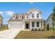 Charming two-story home boasts a manicured lawn, attached garage, and inviting front porch at 116 Hayfield Dr, Lillington, NC 27546