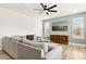 Cozy living room with a large sofa, modern fan, and natural light, perfect for relaxation and entertainment at 116 Hayfield Dr, Lillington, NC 27546