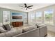 Bright living room features a comfortable sofa, a media cabinet, and multiple windows offering natural light at 116 Hayfield Dr, Lillington, NC 27546