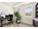 Well-lit home office with a desk, chair, large plant, and a view of the outdoors at 116 Hayfield Dr, Lillington, NC 27546