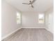 Bright bedroom features neutral walls, modern ceiling fan, and gleaming gray wood-look flooring at 117 Knight Rd Rd, Broadway, NC 27505