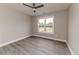 Neutral bedroom features hardwood floors, a ceiling fan, and a window with a view of the neighborhood at 117 Knight Rd Rd, Broadway, NC 27505