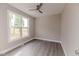 This bedroom has a modern ceiling fan, gray floors and a large scenic window at 117 Knight Rd Rd, Broadway, NC 27505