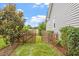 A fenced backyard shows a lovely border and manicured bushes. A cute wooden fence offers privacy and charm at 1228 Shakentown St, Knightdale, NC 27545