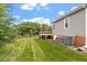 The spacious backyard features a well-kept lawn, mature trees and access to the home's rear deck at 1228 Shakentown St, Knightdale, NC 27545