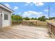 Enjoy outdoor living on this expansive wood deck featuring string lights with views of a fenced yard and distant fields at 1228 Shakentown St, Knightdale, NC 27545