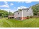 A cozy home exterior shows well-kept lawn and landscaping leading to the rear deck with grey siding at 1228 Shakentown St, Knightdale, NC 27545