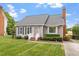 Charming home featuring a well-manicured lawn, mature landscaping, and classic architectural details at 1228 Shakentown St, Knightdale, NC 27545