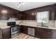 Well-lit kitchen with stainless steel appliances, stainless steel sink, and dark brown cabinets at 1228 Shakentown St, Knightdale, NC 27545