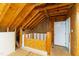 Unfinished attic space with wood framing, insulation, and a doorway to additional storage at 1301 King Cross Ct, Raleigh, NC 27614