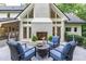 Charming back deck featuring a cozy seating area with comfortable blue chairs and an inviting outdoor fireplace at 1301 King Cross Ct, Raleigh, NC 27614