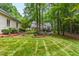 Expansive backyard featuring lush lawn, mature trees, and elegant landscaping with mulched garden beds at 1301 King Cross Ct, Raleigh, NC 27614