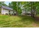 Spacious backyard with manicured lawn, mature trees, and charming outdoor spaces, providing a perfect setting for relaxation at 1301 King Cross Ct, Raleigh, NC 27614