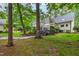 Expansive backyard with lush greenery, stone pathways, and an inviting deck, ideal for enjoying the natural surroundings at 1301 King Cross Ct, Raleigh, NC 27614