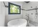 Bright bathroom showing a soaking tub, glass shower with view to the green trees outside at 1301 King Cross Ct, Raleigh, NC 27614