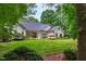 Charming brick home with a manicured lawn and lush landscaping in a serene, wooded setting at 1301 King Cross Ct, Raleigh, NC 27614