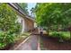 Lovely exterior view showcasing the brick pathway leading to a covered outdoor kitchen and landscaped surroundings at 1301 King Cross Ct, Raleigh, NC 27614