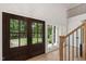 Elegant foyer with wood-framed double doors and a wooden staircase with black railings at 1301 King Cross Ct, Raleigh, NC 27614