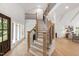 Two-story foyer boasts hardwood floors, staircase with black railings, and decorative wall paneling at 1301 King Cross Ct, Raleigh, NC 27614