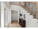 Bright foyer with a staircase, modern light fixtures, and a decorative chest of drawers at 1301 King Cross Ct, Raleigh, NC 27614