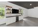 Garage with white cabinetry, beverage cooler, floating shelving and TV, perfect for entertaining at 1301 King Cross Ct, Raleigh, NC 27614
