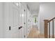 Hallway with wooden floors, white doors and trim, and natural light streaming through an open door at 1301 King Cross Ct, Raleigh, NC 27614