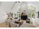 Bright living room features vaulted ceilings, a fireplace, and expansive windows with backyard views at 1301 King Cross Ct, Raleigh, NC 27614