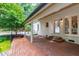 Spacious brick patio with white columns, perfect for outdoor relaxation and entertaining, surrounded by lush greenery at 1301 King Cross Ct, Raleigh, NC 27614