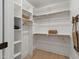 Walk-in closet featuring custom shelving, wooden rods, and ample storage space at 1301 King Cross Ct, Raleigh, NC 27614