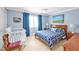 Light blue bedroom with wood furnishings, a queen size bed, and a baby crib at 14 Marigold Pl, Durham, NC 27705