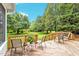 Wooden deck with outdoor seating surrounded by lush green landscaping and a clear blue sky at 14 Marigold Pl, Durham, NC 27705