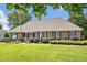 Beautiful single-story brick home with blue shutters, manicured landscaping, and lush green lawn at 14 Marigold Pl, Durham, NC 27705