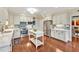 Bright kitchen with white cabinetry, stainless steel appliances, central island, and blue backsplash tiles at 14 Marigold Pl, Durham, NC 27705
