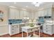 Beautifully designed kitchen features stainless steel appliances, island, and blue tiled backsplash at 14 Marigold Pl, Durham, NC 27705