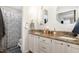 Bright bathroom with granite countertops, double sinks, and a shower with a blue patterned curtain at 1426 Cedar Branch Ct, Wake Forest, NC 27587