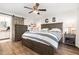 Cozy bedroom with wood floors, a ceiling fan, and a sliding barn door leading to the bathroom at 1426 Cedar Branch Ct, Wake Forest, NC 27587