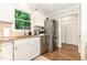 Bright kitchen featuring stainless steel appliances, white cabinets, and hardwood floors at 1426 Cedar Branch Ct, Wake Forest, NC 27587