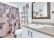 This bathroom features a vanity with a sink, toilet, and a stylish shower curtain at 144 Shawnee Dr, Louisburg, NC 27549