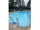 View of the community swimming pool with ladder entry and chairs at 144 Shawnee Dr, Louisburg, NC 27549
